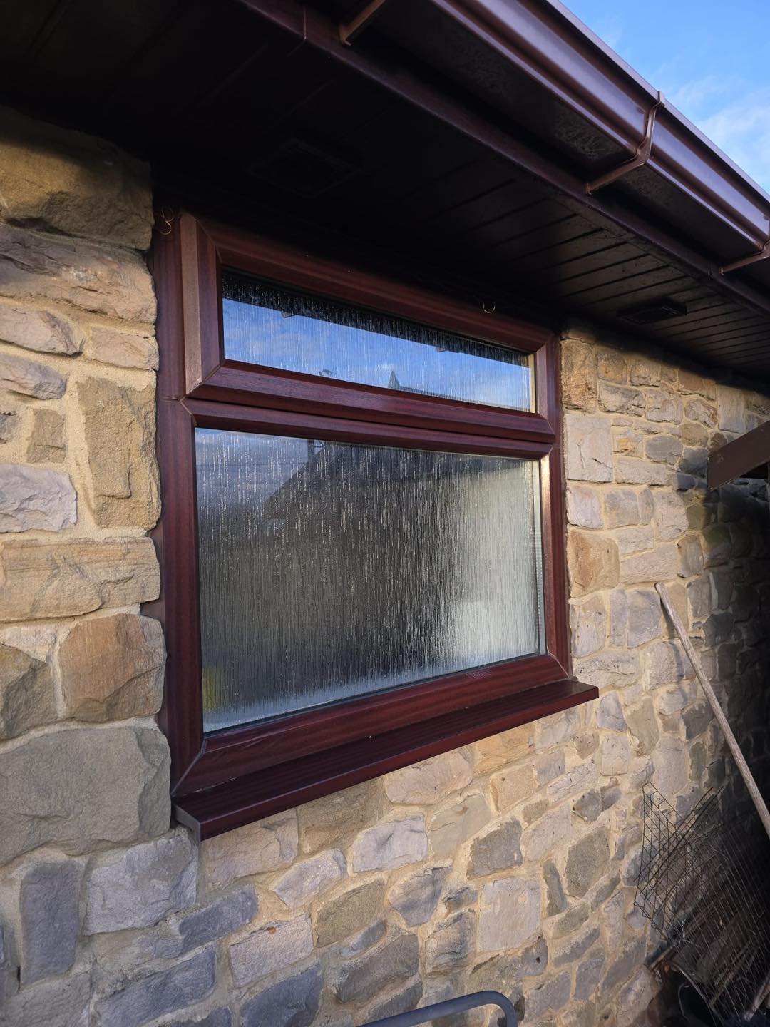 Obscure glass window with a dark wood frame.