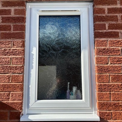 A patterned glass bathroom window.